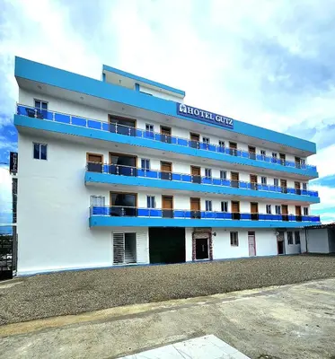 a white building with blue balconies on it at Hotel Gutz in San Felipe de Puerto Plata