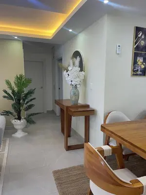 a dining room with a vase of flowers on a table at Hermoso apto amueblado a 5 minutos de downtown Punta Cana in Punta Cana