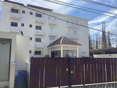 a white building with a fence in front of it at Apartment with ocean front view in Juan Dolio