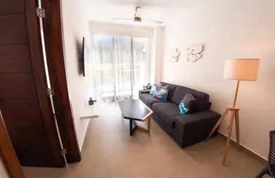 a living room with a couch and a window at Las Golondrinas Cabarete in Cabarete