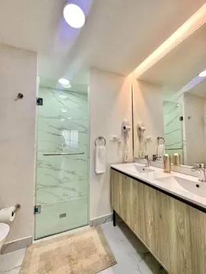 a bathroom with a glass shower and a sink at Comfy 2BR City Center Condo in Los Prados