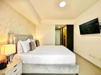 a bedroom with a bed and a tv on the wall at Comfy 2BR City Center Condo in Los Prados