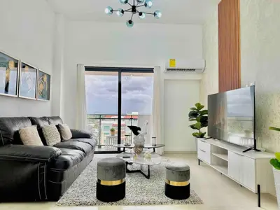 a living room with a couch and a television at Comfy 2BR City Center Condo in Los Prados