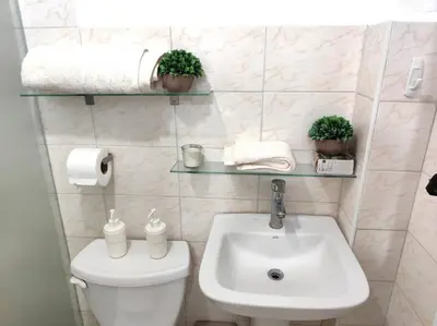 a bathroom with a white toilet and a sink at Your Tropical HouseRD in La Francia