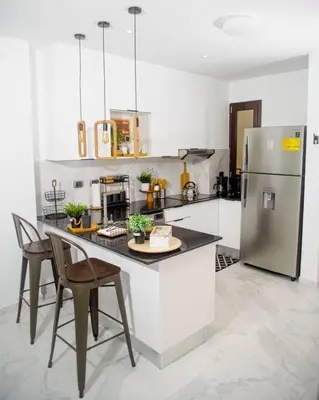 a kitchen with a refrigerator and a table and chairs at The Peña family suite in Punta Cana