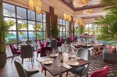 a restaurant with tables and chairs and windows at Bahia Principe Luxury Ambar - Adults Only All Inclusive in Punta Cana