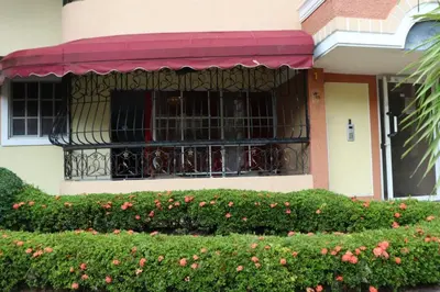 a building with a balcony with flowers in front of it at Three-Bedroom Apartment 3 in Santo Domingo