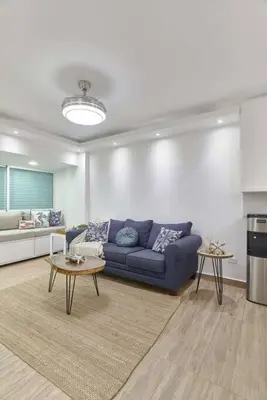 a living room with a blue couch and a table at El Retiro Juan Dolio Beach by Elital Luxury in Villas del Mar