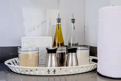 a tray with condiments and a bottle of wine at Chic Centric 1BR Apt, King Bed in Los Prados