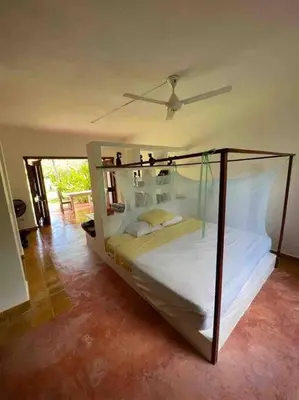 a bedroom with a large bed with a fan at Beach, nature and relaxation in Las Terrenas