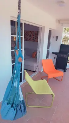 a living room with a swing and a chair at guababerry Juan dolio in Los Conucos