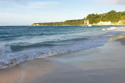 a beach with the ocean and the shoreline at Villa LiMar in Río San Juan