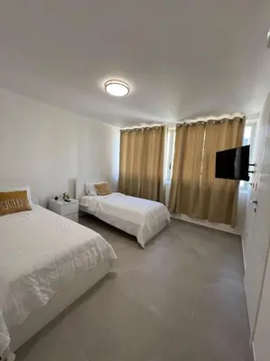 a bedroom with two beds and a flat screen tv at Apartment in Playa Nueva Romana in San Pedro de Macorís