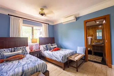 a bedroom with two beds and a mirror at Sunset Cove at Balcones in Las Terrenas