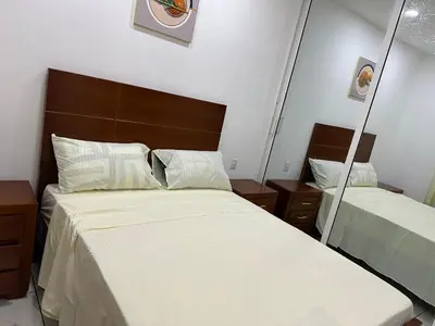 a bedroom with a mirror next to a bed at Apartamentos victoria in Las Terrenas