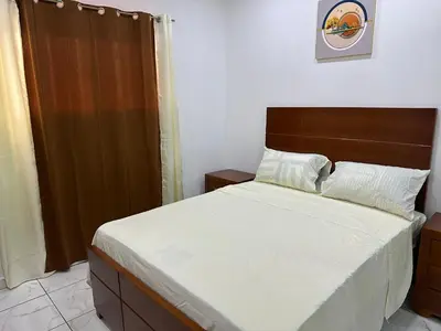 a bedroom with a large bed with a wooden headboard at Apartamentos victoria in Las Terrenas