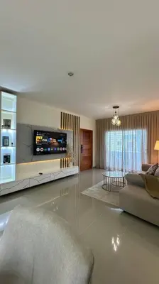 a living room with a couch and a television at Hospedaje Lujoso en Boca Chica in Santo Domingo