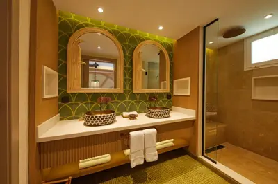 a bathroom with a shower and two sinks and mirrors at Cayo Levantado Resort - All Inclusive in Santa Bárbara de Samaná