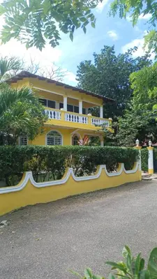 a yellow house with a fence in front of it at Casa de adela in Cruce de Veragua