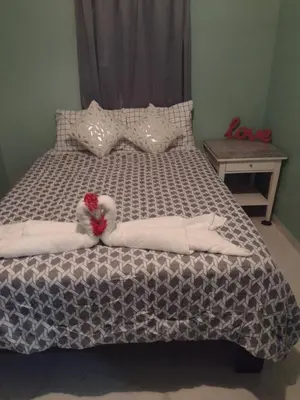 a bed with a white comforter with a red heart at Casa de adela in Cruce de Veragua