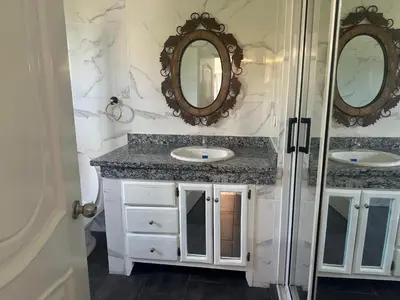 a bathroom with two sinks and two mirrors at Casa las Américas in La Alianza
