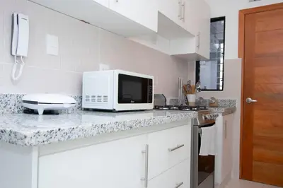 a white kitchen with a microwave on a counter at APT 3 HAB Avenida España Piso 1 in La Viva