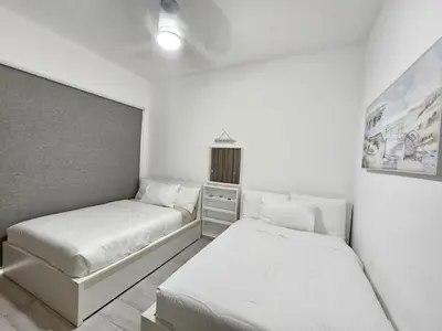 two beds in a small room with white walls at Melody 2BDR Condo with Pool View in Coral Bay #2 in Punta Cana