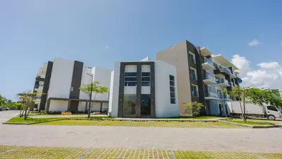a building with two tall buildings in a parking lot at Melody 2BDR Condo with Pool View in Coral Bay #2 in Punta Cana