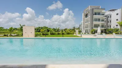 a large swimming pool in front of a building at Melody 2BDR Condo with Pool View in Coral Bay #2 in Punta Cana