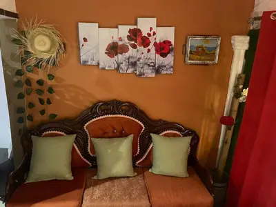a chair with pillows and pictures on the wall at Tropical 2 in La Hondonada