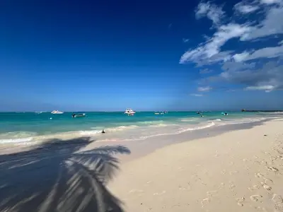 a view of a beach with people in the ocean at Luxury Beach Penthouse with Pool, BBQ, AC, Wi-Fi, 5-Min Walk to El Cortecito & Bavaro Beaches, Punta Cana in Punta Cana