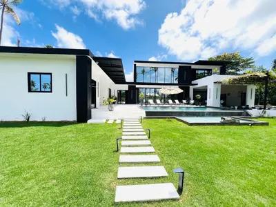 a house with a grass yard with a staircase at Casa B&W, Villa luxueuse Exceptionnelle, 8 personnes, à 1 min de la plage in Las Galeras