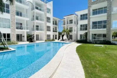 a swimming pool in front of a large apartment building at Brand New beach and golf condo in Punta Cana in Punta Cana