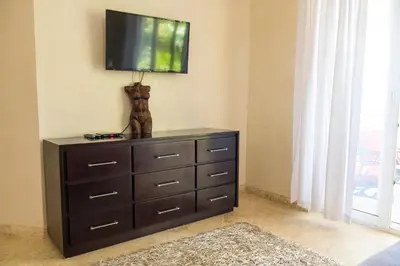 a dresser with a television on top of it at Hispaniola Luxury Ocean Front Condo in Sosúa