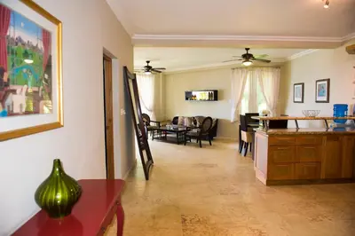 a living room with a kitchen and a dining room at Hispaniola Luxury Ocean Front Condo in Sosúa