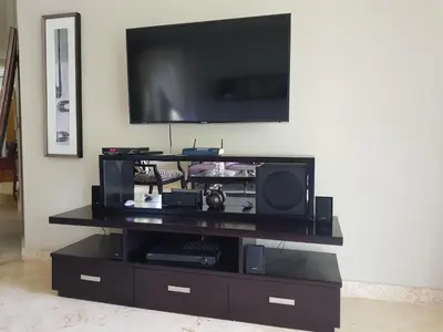 a black entertainment center with a flat screen tv on a wall at Hispaniola Luxury Ocean Front Condo in Sosúa