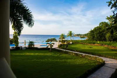 a view of the beach from the balcony of a resort at Hispaniola Luxury Ocean Front Condo in Sosúa