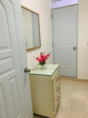 a vase of flowers on a dresser with a mirror at Apartamento Familiar in San Felipe de Puerto Plata