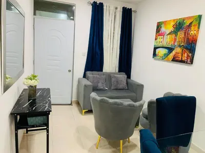 a living room with a chair and a table at Apartamento Familiar in San Felipe de Puerto Plata