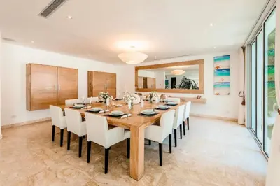 a dining room with a wooden table and white chairs at New private luxury villa in Punta Cana in Punta Cana