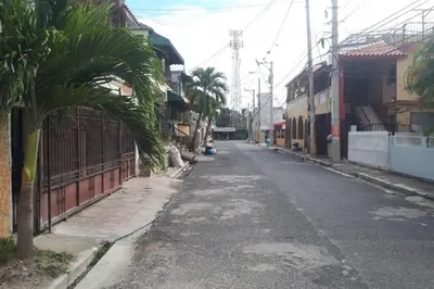an empty street with a palm tree and buildings at Confortable apartaestudio en Santo Domingo Este in Santo Domingo