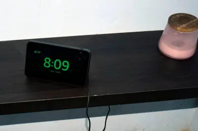 an alarm clock sitting on a table next to a candle at Confortable apartaestudio en Santo Domingo Este in Santo Domingo