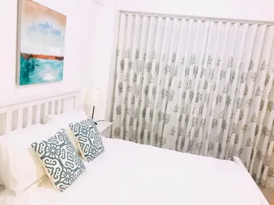 a white bedroom with a bed and a window at Boca chica Apartment Near the bech in Boca Chica