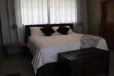 a bedroom with a large white bed with black pillows at Villa Cantares del Rio in La Cuaba