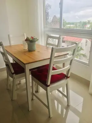 a wooden table and chairs with a potted plant on it at Hermoso Apartamento cerca de la playa, Restaurantes, Supermercados, Restaurantes, Aeropuertos, parqueo gratis in Boca Chica