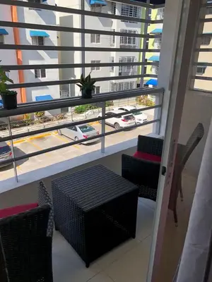 a balcony with a table and chairs and a view of a city at Hermoso apartamento in Santo Domingo