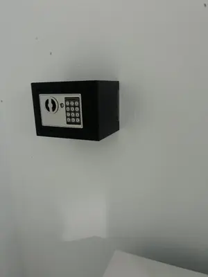 a black microwave hanging on a white wall at Hotel Hannabi in Boca Chica