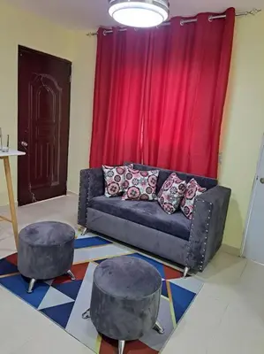 a living room with a couch and two stools at Encantador Apartamento Pequeño in Hornillo