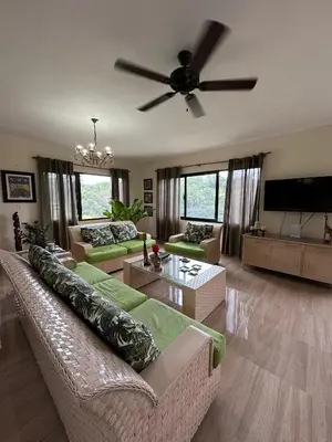 a living room with a couch and a ceiling fan at Villa RG in Jarabacoa