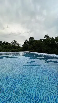 a pool of blue water with trees in the background at Villa RG in Jarabacoa